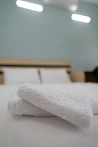 una pila de toallas blancas sentadas encima de una cama en Villa Hania Boutique Hotel - Adults only, en Side