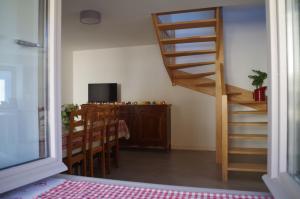 een kamer met een trap, een tafel en een televisie bij La maison de Michelle in Lugny