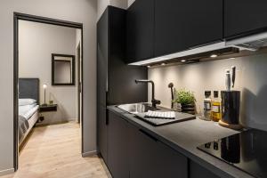 uma cozinha com um lavatório e uma cama num quarto em The APARTMENTS Company- Frogner em Oslo
