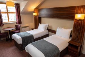 Pokój hotelowy z 2 łóżkami i krzesłem w obiekcie The Fernhurst by Greene King Inns w mieście Blackburn