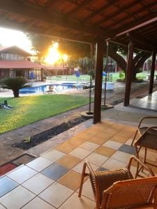 eine Terrasse mit Stühlen und einem Pool in der Unterkunft Pousada Beco da Lua in Olímpia