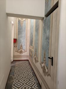 pasillo con puerta y suelo de baldosa en Maison Belle Époque & suites, en Oristano