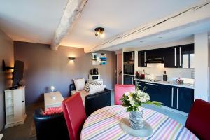 cocina y sala de estar con mesa y sillas rojas en L'Aigrette, en Le Hanouard