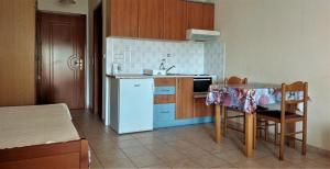 a kitchen with a white refrigerator and a table at HotelApart Filoxenia in Alexandroupoli