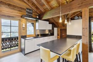 a kitchen with white cabinets and a black counter top at Chalet Reine by Mrs Miggins in Val-d'Illiez