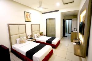 a hotel room with two beds and a television at HOTEL BLUE PEARL in Bhopal