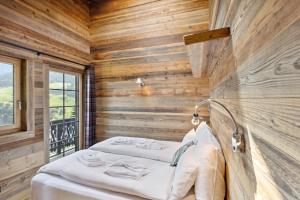 a room with a bed in a wooden wall at Chalet Reine by Mrs Miggins in Val-d'Illiez