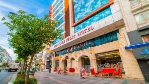 a building with red chairs in front of it at Old Town Point Hotel & Spa Antalya in Antalya