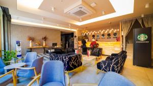 a lobby with blue chairs and tables and a person at Old Town Point Hotel & Spa Antalya in Antalya