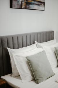 a pile of white pillows on a bed at M & N Guesthouse in Volos
