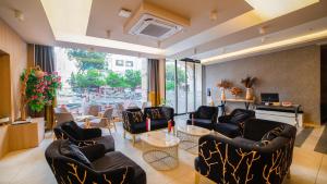 a waiting room with black chairs and tables and a piano at Old Town Point Hotel & Spa Antalya in Antalya