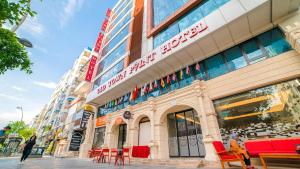 a building with red chairs in front of it at Old Town Point Hotel & Spa Antalya in Antalya