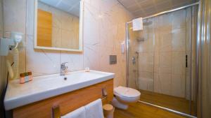 a bathroom with a shower and a sink and a toilet at Old Town Point Hotel & Spa Antalya in Antalya