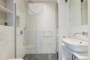 uma casa de banho branca com um chuveiro e um lavatório. em ShortStayPoland Jagiellońska (B133) em Varsóvia