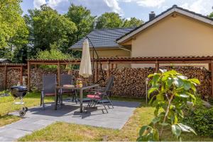 un patio con sombrilla, mesa y sillas en Ferienwohnungen Wildau am Werbellinsee, en Schorfheide