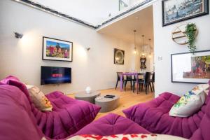 a living room with purple couches and a table at Luxury Roof Terrace Townhouse in Manchester
