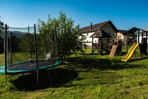 a park with a playground with a slide at Bucovina Lodge Pension in Vama
