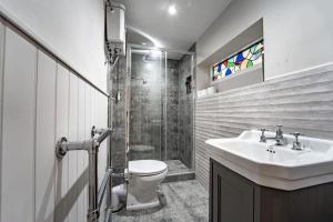 a bathroom with a sink and a toilet and a shower at Large 5-Bedroom Farmhouse Sleeps 10 with Parking and Wifi in Potter Street +17 photos