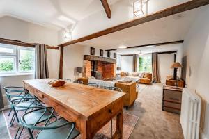 5 Bed Farmhouse Suitable for Contractors Private Parking في Potter Street: غرفة معيشة مع طاولة وكراسي خشبية