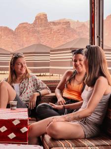 Tres chicas sentadas en un tren en el desierto en Desert Bird Camp en Wadi Rum