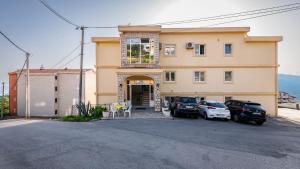 a building with two cars parked in front of it at Prijevor Apartments in Budva