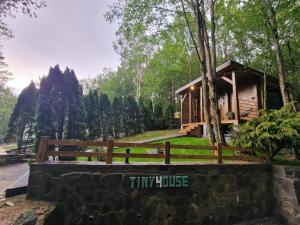 a tiny house in the woods with a fence at Tiny House 4 Two in Văliug
