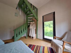 a bedroom with a green staircase and a window at Saint Friday Cottage - Retreat, Garden and Forest in Vîlsăneşti