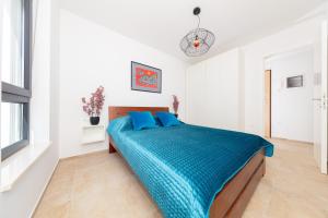 a white bedroom with a bed with blue pillows at Apartman Seaside 5 in Banjole +40 photos