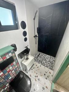 a bathroom with a black toilet and a sink at Tiny House 4 Two in Văliug
