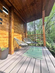 a porch of a cabin with two chairs on it at Tiny House 4 Two in Văliug