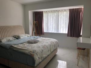 1 dormitorio con cama y ventana en 田园居 en Orpington
