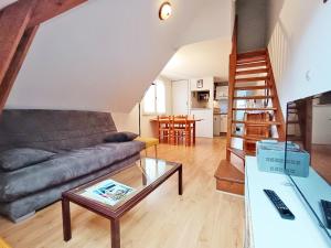 uma sala de estar com um sofá e uma mesa em Chez Charlotte, T3 duplex, vue montagne, parking gratuit, 4 personnes em Luchon