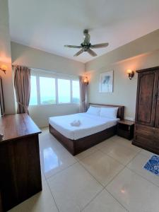 Un dormitorio con una cama y un ventilador de techo. en Aloka Seaview Apartment, en Batu Ferringhi