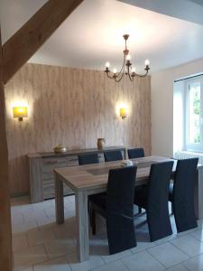 a dining room with a wooden table and blue chairs at Chez Tartine in Thénioux