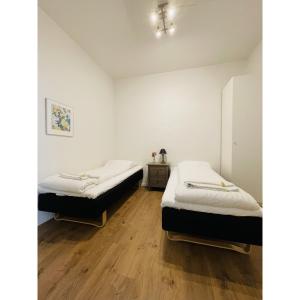 two beds in a room with wooden floors at ApartmentInCopenhagen Apartment 1554 in Copenhagen