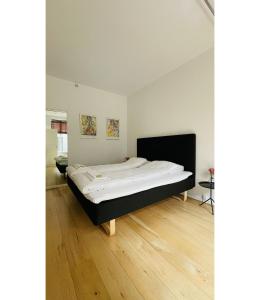 een groot bed in een kamer met een houten vloer bij ApartmentInCopenhagen Apartment 1555 in Kopenhagen