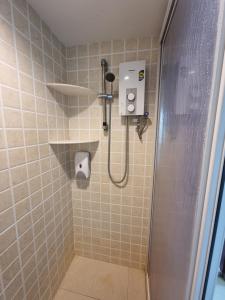 La salle de bains carrelée est pourvue d'une douche. dans l'établissement Aloka Seaview Apartment, à Batu Ferringhi