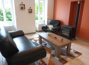 Chez Tartine في Thénioux: غرفة معيشة مع كرسيين جلديين وطاولة قهوة