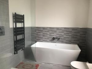 a white bath tub in a bathroom with a toilet at 田园居 in Orpington