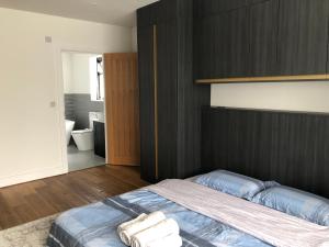 1 dormitorio con 1 cama con toallas en 田园居 en Orpington