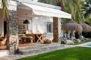 a patio with a table and an umbrella at Villa bonita en Alicante con piscina in Elche