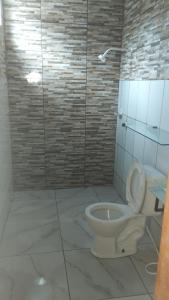 a bathroom with a white toilet and a shower at Pousada Nordestino próx ATALAIA in Salinópolis