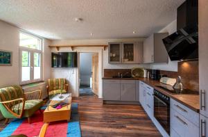 a kitchen with white cabinets and a living room at Ferienwohnung Schulstr 8 Müden in Müden