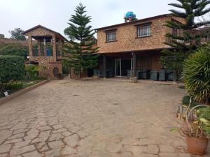 a house with a large driveway in front of it at Hôtel restaurant le MIAMIAM GLOUGLOU in Ambositra