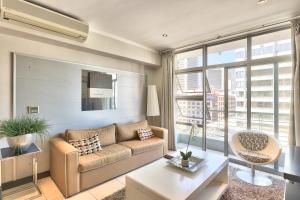 a living room with a couch and a table at The Icon Studio Apartment 1000 in Cape Town