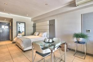a bedroom with a bed and a glass table at The Icon Studio Apartment 1000 in Cape Town +23 photos