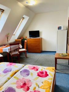 a room with a bed and a table and a refrigerator at Active Wellness hotel U zlaté rybky in Vyškov