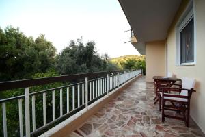 a balcony with two chairs and a table on it at Villa Eirini Agia Varvara Lesvos in Plomari