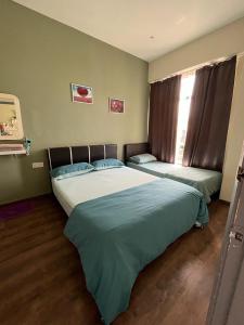 a bedroom with two beds and a window at Homestay Melaka Mahkota Melaya Raya in Malacca