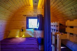 a bedroom with a bed in a wooden cabin at Domaine Joseph LAFARGE Wine Resort Oeno-tonneaux expérience in Lugny